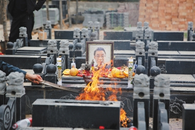 2016年4月13日,陜西咸陽(yáng),魏則西的墓上擺滿了他生前愛(ài)吃的水果、餅干、巧克力。本版圖片/CFP