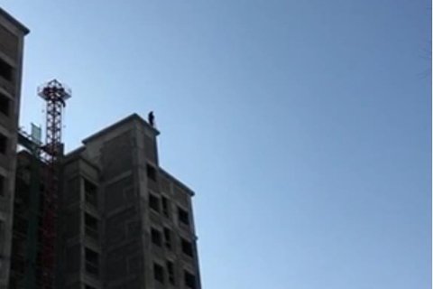 嫌犯在樓頂被發(fā)現(xiàn),正與警方對峙。視頻截圖